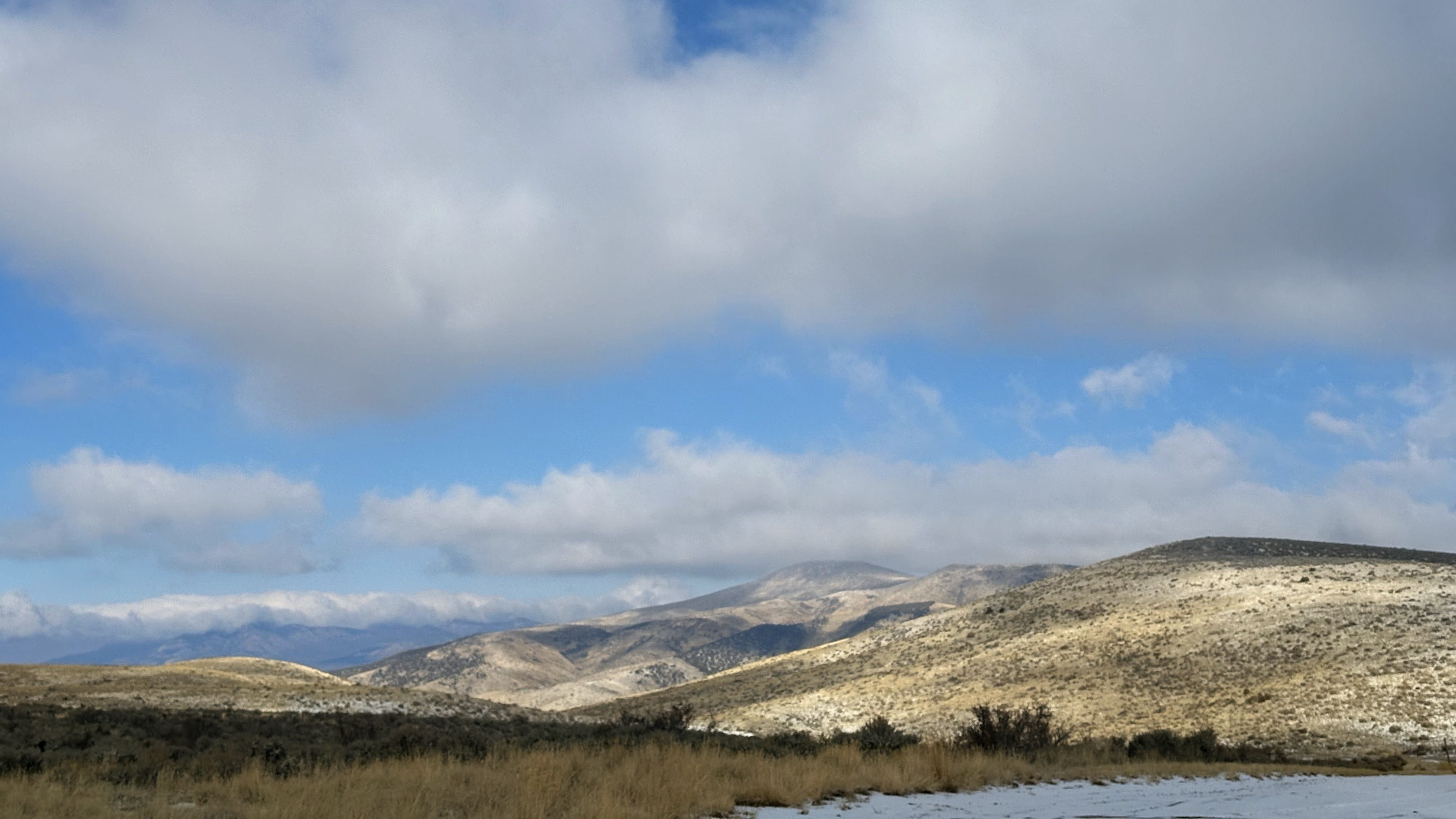 landscape of rolling hills a clouds on a blue sky