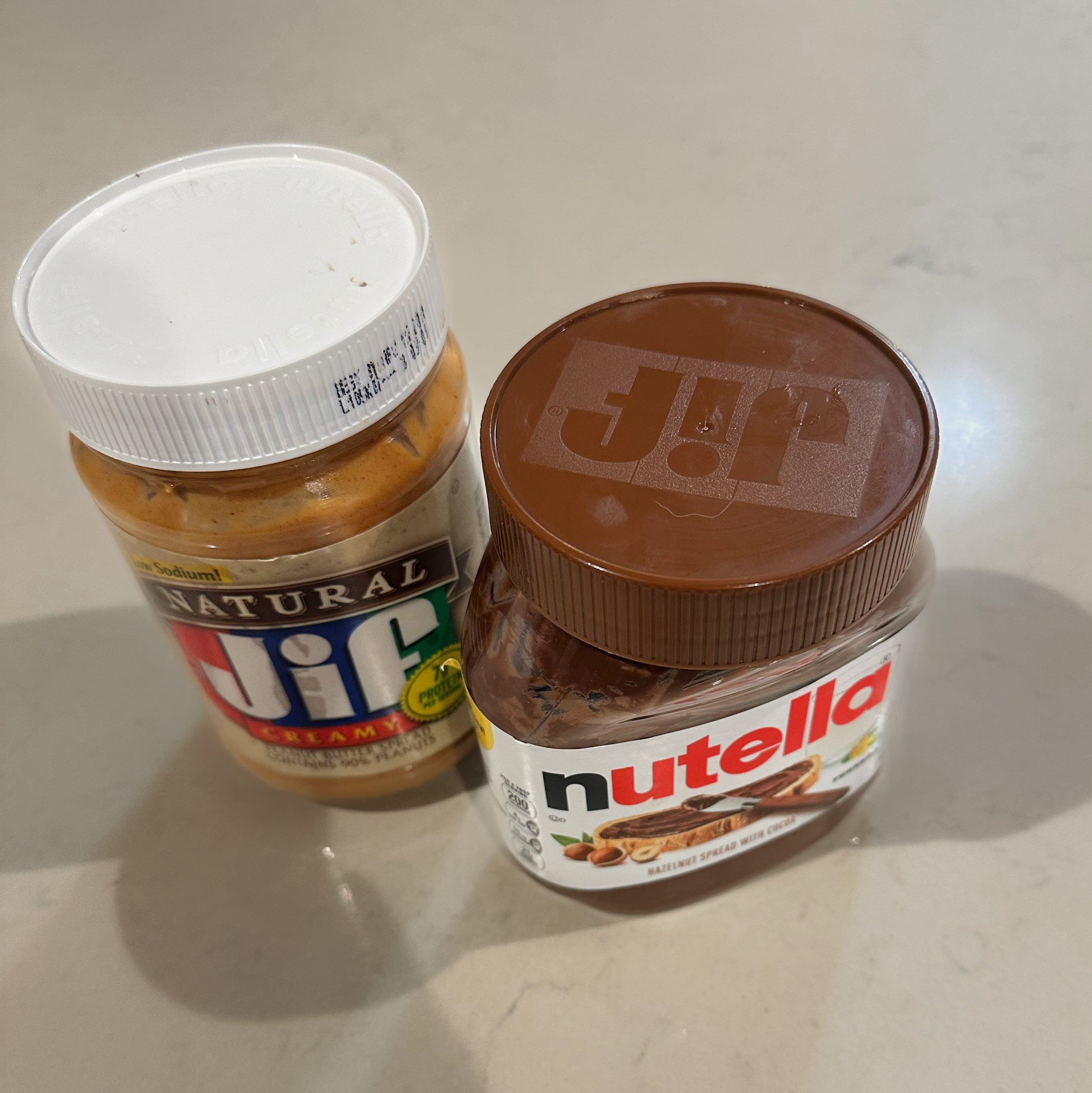 a Jif peanut butter jar and a Nutella jar with swapped lids